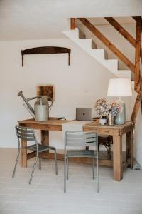 einen Schreibtisch mit einem Laptop und einem Tisch mit Stühlen in der Unterkunft Domaine St-Amand in Saint-Amand-de-Coly