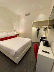 a bedroom with a white bed and a red chair at Lisbon City Hollywood Hotel by City Hotels in Lisbon