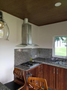 eine Küche mit einem Herd, einem Waschbecken und einem Fenster in der Unterkunft Casita Boquete in Boquete