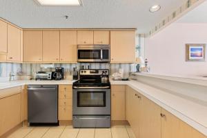 a kitchen with stainless steel appliances and wooden cabinets at Fabulous Kingston Plantation 1009, Walk to Dining, Shops, Relax in Myrtle Beach