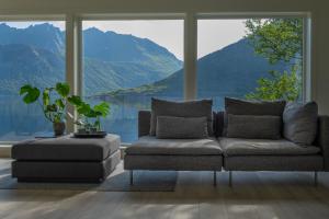 un soggiorno con divano e una grande finestra di Polar Panorama Lodge a Fjordgård