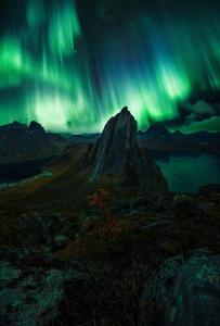 ein Bild der Nordlichter am Himmel über einem Berg in der Unterkunft Polar Panorama Lodge in Fjordgård