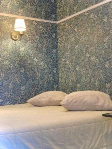 um quarto com uma cama com papel de parede azul e dourado em Poilsis Birutės alėjoje em Palanga