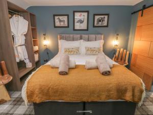 una camera da letto con un grande letto con cuscini sopra di Well Cottage a Beverley