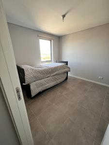 1 dormitorio con cama y ventana en Mercado de Propiedades en Córdoba