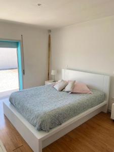 um quarto com uma cama com almofadas cor-de-rosa e uma janela em 3 bedrooms villa with city view private pool and enclosed garden at Sao Miguel do Prado 