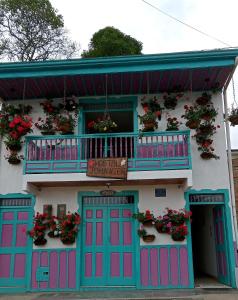 un edificio con puertas rosas y azules y balcón en Hostal Johnnier, en Salento