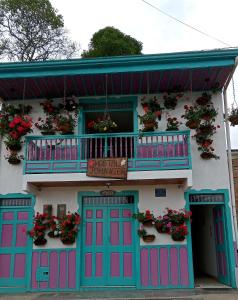 a building with pink and blue doors and a balcony at Hostal Johnnier in Salento