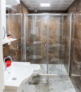 a bathroom with a shower and a toilet and a sink at ABC Apart Hotel in Antalya