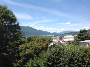 uitzicht op een stad met bergen en bomen bij Suite Célestine Palace Excelsior vue lac in Aix-les-Bains