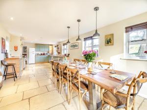 uma cozinha e sala de jantar com uma mesa de madeira e cadeiras em Bridge Cottage em High Ham
