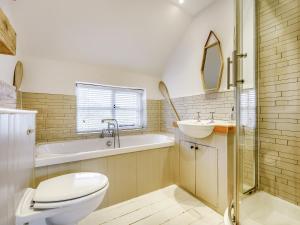 a bathroom with a toilet and a sink and a tub at Bridge Cottage in High Ham