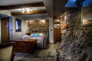 ein Schlafzimmer mit einem Bett und einer Steinmauer in der Unterkunft La Voce del Fiume Dimora di Charme in Brienza