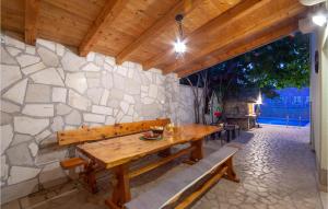a stone wall with a wooden table and benches at Gorgeous Home In Kamenmost With Kitchen in Kamenmost