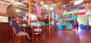dos hombres sentados en un bar en un restaurante en Hotel Aldea Pura Vida en Puntarenas