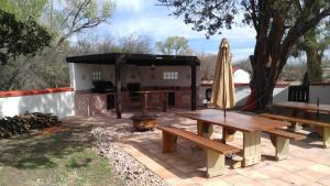 un patio con mesas de picnic y una sombrilla en Rancho Santa Cruz, en Tubac