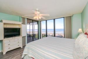 Un dormitorio con una cama y un ventilador de techo. en Sand Dollar 2-201, en St. Augustine
