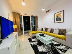 a living room with a couch and a tv at skynest holiday homes sea view 1 bedroom apartment dubai marina 1011 in Dubai