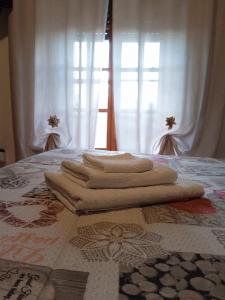 un grupo de toallas en una cama con ventana en L'oasi di Alice, en Sermoneta