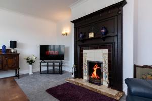 Copley的住宿－H C property - Burnlea Cottage，客厅设有壁炉和电视。