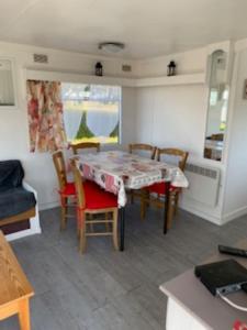 a dining room with a table and chairs in a room at Mobilhome 4pers avec terrasse in Saint-Martin-aux-Buneaux