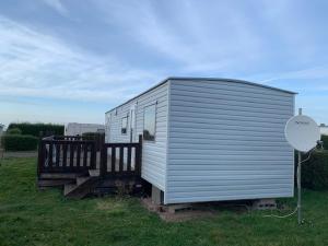 a tiny house in a field with a sign at Mobilhome 4pers avec terrasse in Saint-Martin-aux-Buneaux