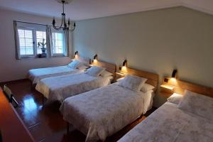 a room with three beds with lights on them at La Casa del Rio. in La Serna