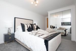a white bedroom with a large white bed with pillows at Panacotta House - Luxury 1 Bed Apartment in Aberdeen in Aberdeen