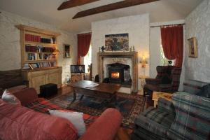 a living room with a couch and a fireplace at Wood Quay - A truly unique, seafront experience! in Carlingford