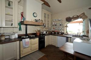 a kitchen with white cabinets and a black stove top oven at Wood Quay - A truly unique, seafront experience! in Carlingford