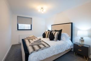 a bedroom with a bed with black and white pillows at Panacotta House - Luxury 1 Bed Apartment in Aberdeen in Aberdeen