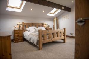 a bedroom with a wooden bed and two night stands at Tockwith Lodge Barn in York