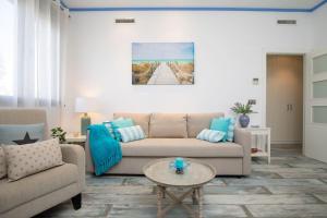 a living room with a couch and a table at ApartUP Patacona Azzure in Valencia