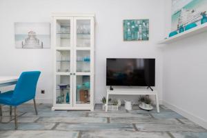 a living room with a tv and a blue chair at ApartUP Patacona Azzure in Valencia