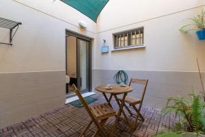 a patio with a table and chairs in front of a building at ApartUP Patacona Azzure in Valencia