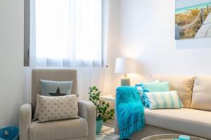 a living room with a couch and a chair at ApartUP Patacona Azzure in Valencia