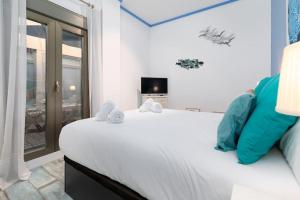 a bedroom with a large white bed and a window at ApartUP Patacona Azzure in Valencia