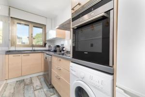 a kitchen with a dishwasher and a large appliance at ApartUP Patacona Azzure in Valencia