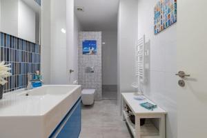 a bathroom with a tub and a toilet and a sink at ApartUP Patacona Azzure in Valencia
