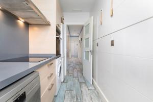 a kitchen with white cabinets and a washer and dryer at ApartUP Patacona Azzure in Valencia