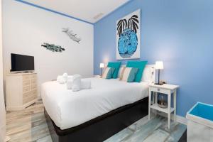 a bedroom with a large bed and a tv at ApartUP Patacona Azzure in Valencia