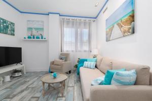 a living room with a couch and a table at ApartUP Patacona Azzure in Valencia