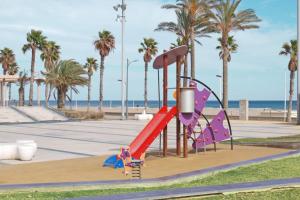 a playground at the beach with palm trees at ApartUP Patacona Azzure in Valencia