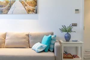 a couch with pillows and a table with a picture of a bridge at ApartUP Patacona Azzure in Valencia