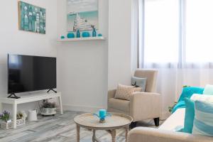 a living room with a couch and a tv at ApartUP Patacona Azzure in Valencia