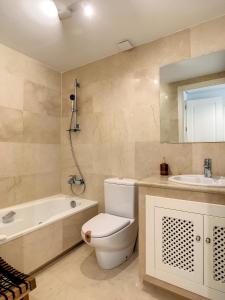 a bathroom with a toilet and a tub and a sink at Roda Golf Resort - 8809 in San Javier