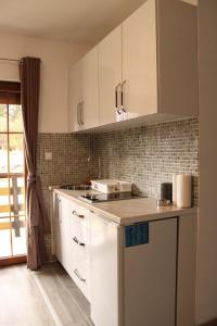 a kitchen with white cabinets and a counter top at Eleon Motel in Brezovica