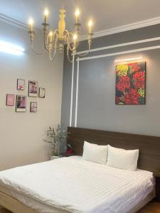 ein Schlafzimmer mit einem großen Bett mit einem Kronleuchter in der Unterkunft Mộc Hương Hotel in Phú Thọ