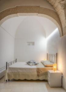 1 dormitorio con 1 cama en una habitación blanca en Home Pedra, en Ceglie Messapica