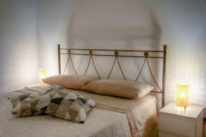 ein Schlafzimmer mit einem Bett mit zwei Lampen in der Unterkunft Home Pedra in Ceglie Messapica